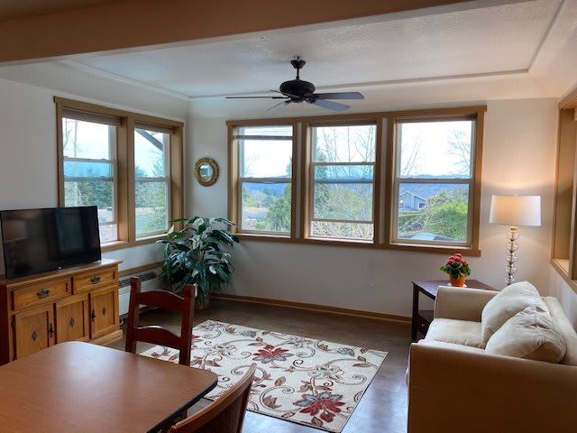 A cozy living room with large windows and comfortable furnishings.