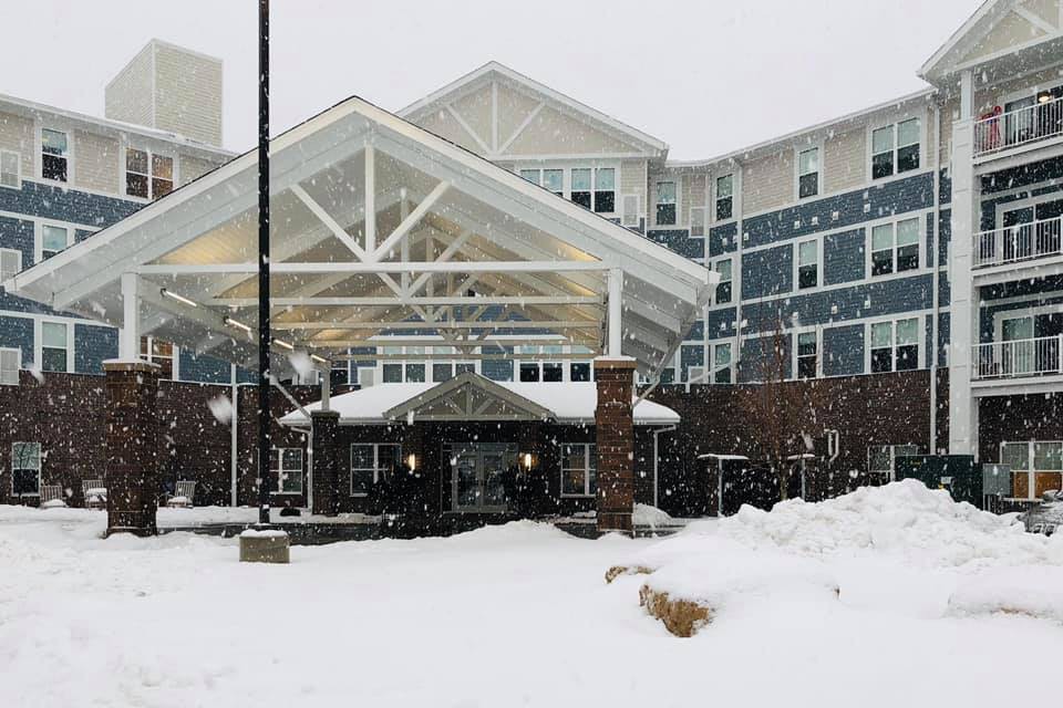 A snowy winter day at the entrance of a hotel.