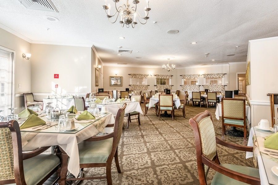 Elegant dining room with neatly arranged tables and a chandelier.