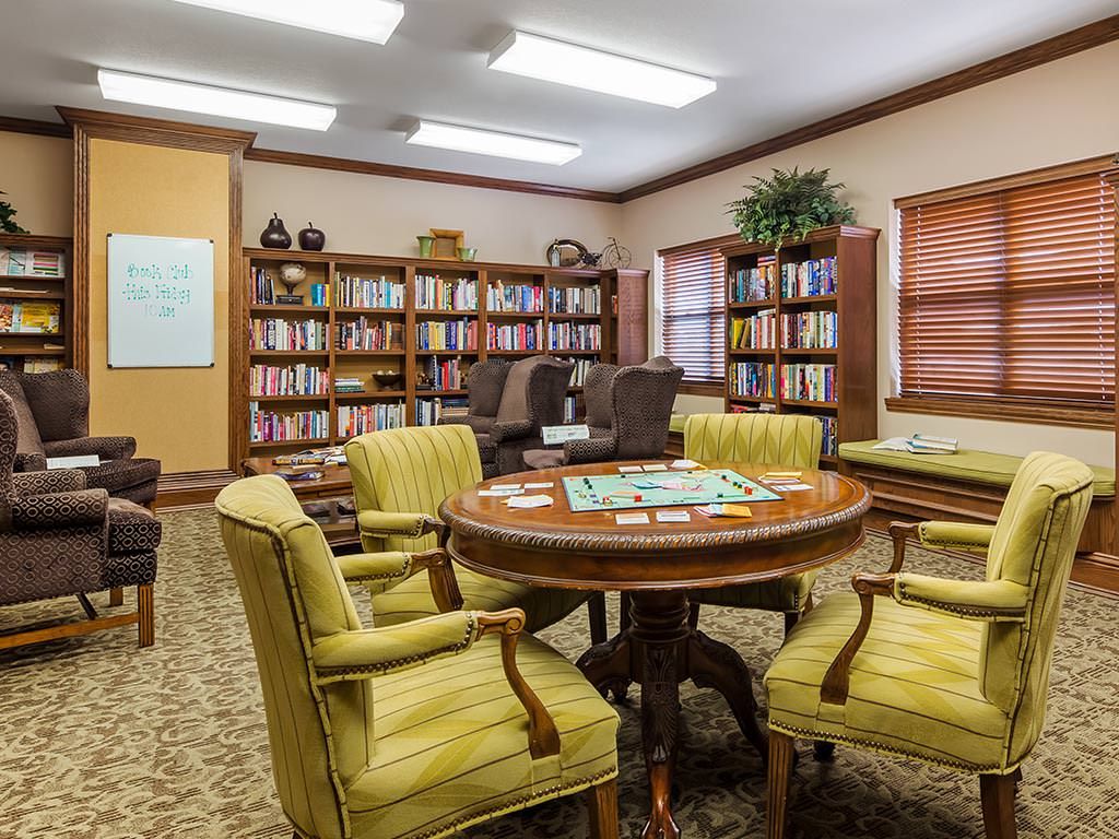 A cozy library reading room with comfortable seating and bookshelves filled with books.