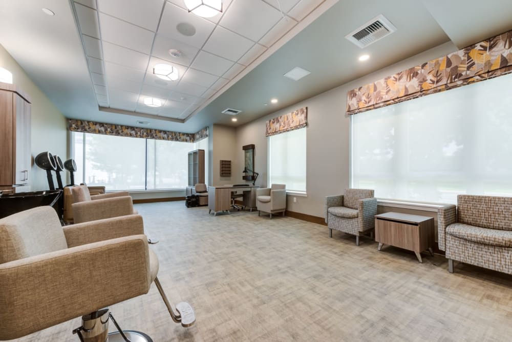 A modern salon interior with chairs and mirrors, featuring large windows and stylish decor.