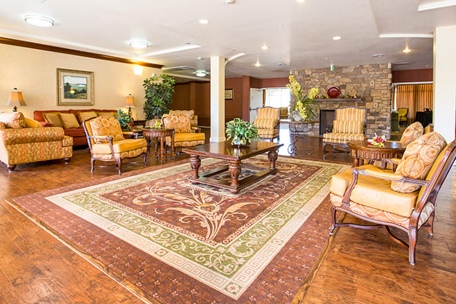 A spacious living room with elegant furniture and a large decorative rug.