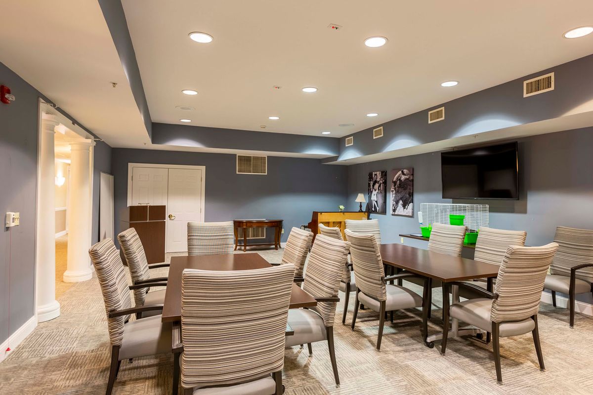 A modern conference room with tables and chairs arranged for a meeting.