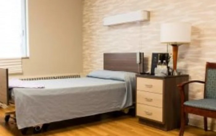 A minimalist bedroom with a single bed, nightstand, and modern decor.