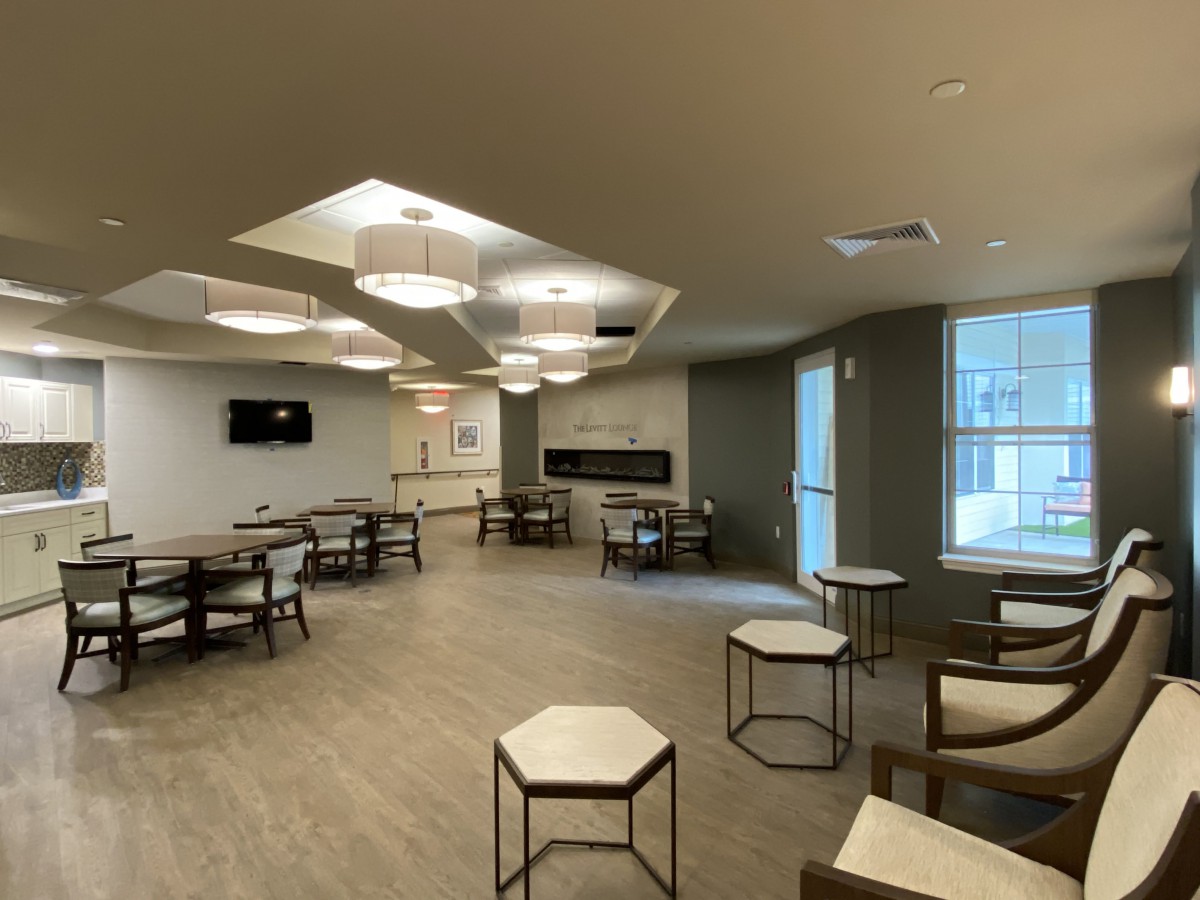 A modern lounge area with tables, chairs, and contemporary lighting fixtures.