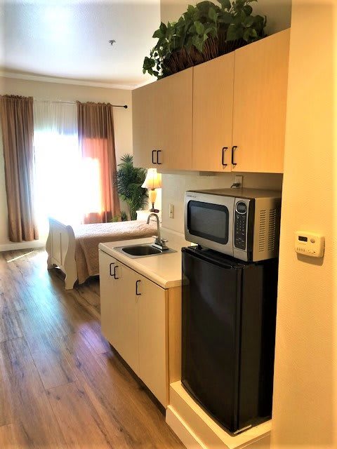 Compact studio apartment with a kitchenette and cozy sleeping area.