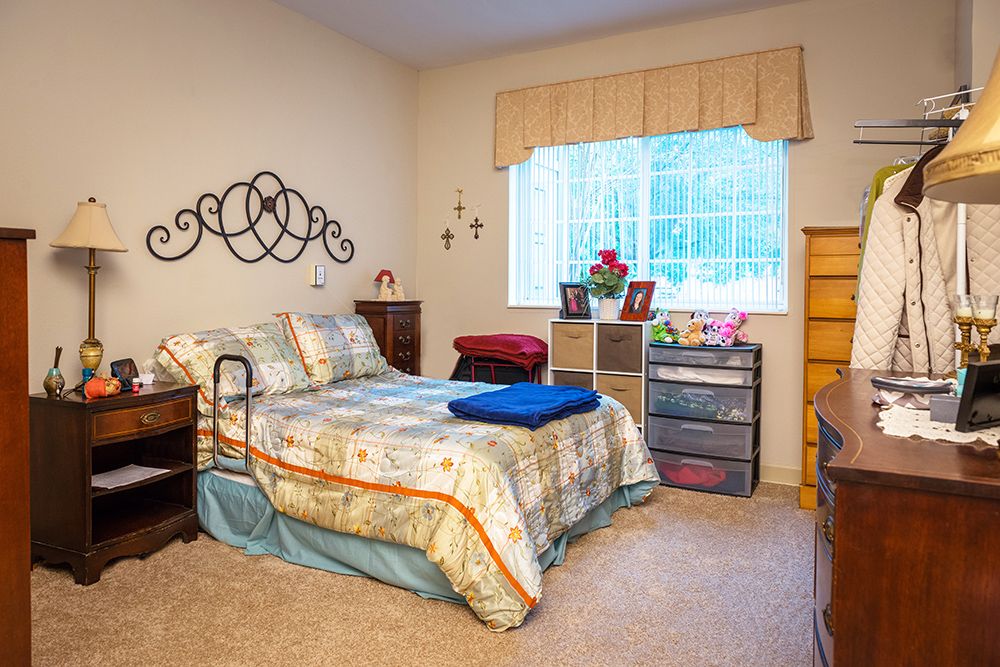 A cozy bedroom with a neatly made bed and natural light coming through the window.