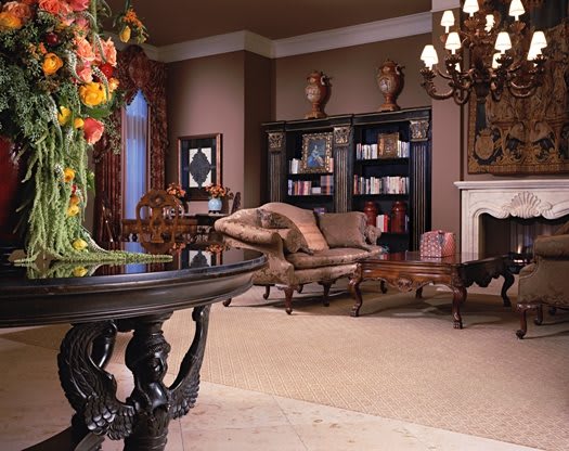 A luxurious and elegantly decorated living room featuring antique furniture, a chandelier, and a cozy fireplace.