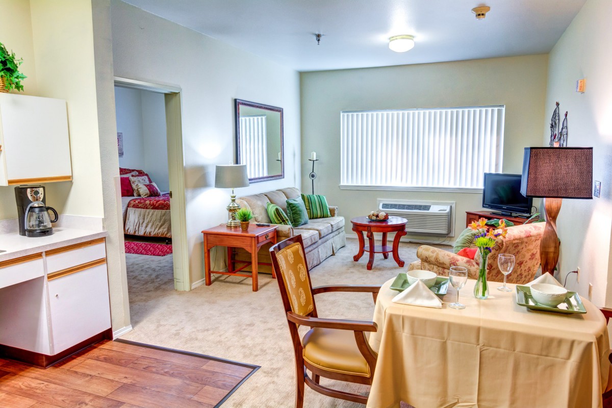 A cozy living room and adjacent bedroom in a well-furnished apartment.