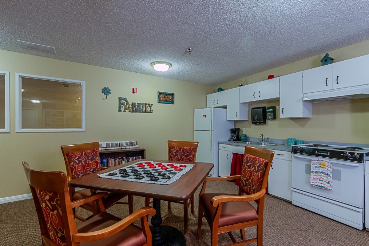 A cozy kitchen and dining area with a table set up for a game of checkers.