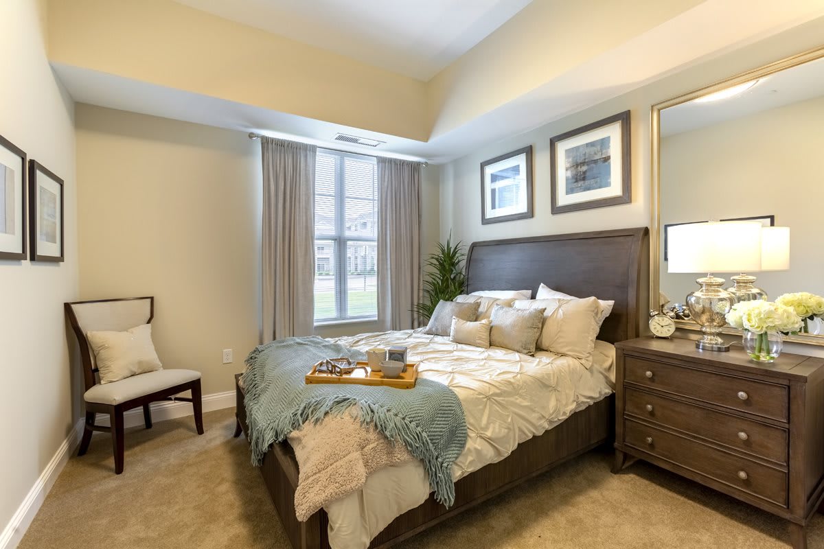 A well-decorated bedroom featuring a comfortable bed, elegant furniture, and soft lighting.