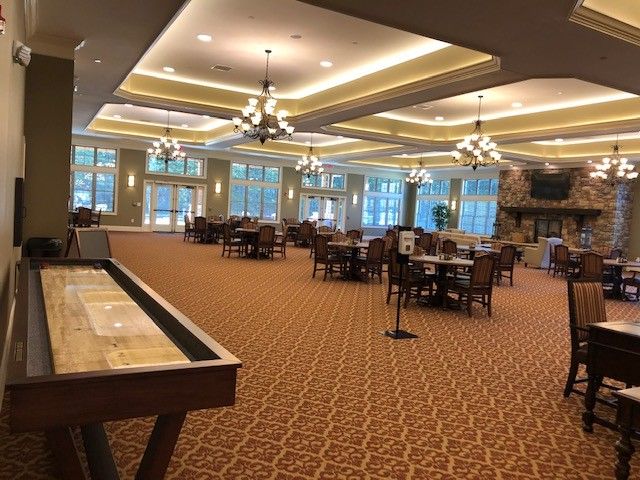 Spacious dining and lounge area with elegant chandeliers and large windows.