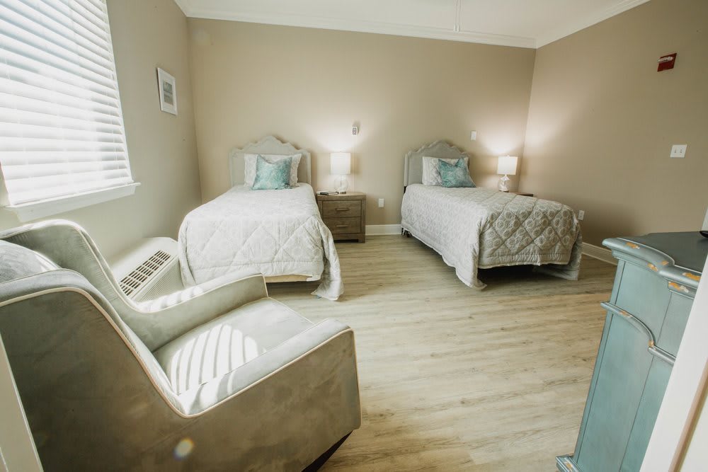 A cozy bedroom featuring twin beds with soft lighting and neutral tones.
