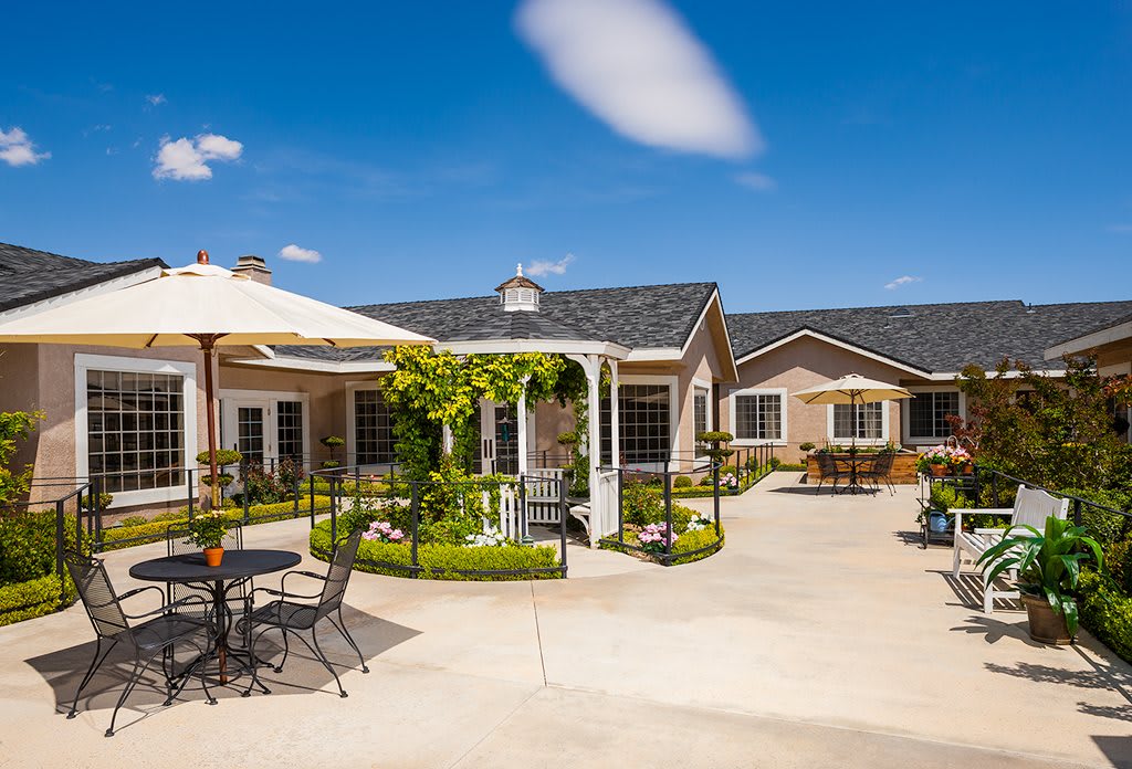 A peaceful courtyard with seating under a sunny blue sky.
