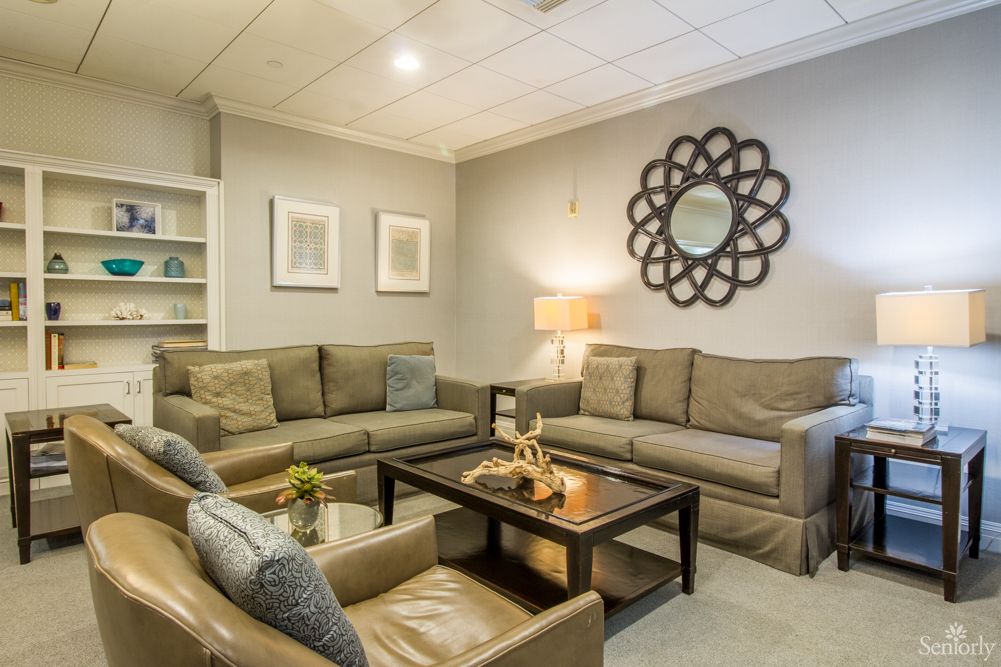 A cozy and modern living room with comfortable sofas, an armchair, and a central coffee table adorned with decorative items.