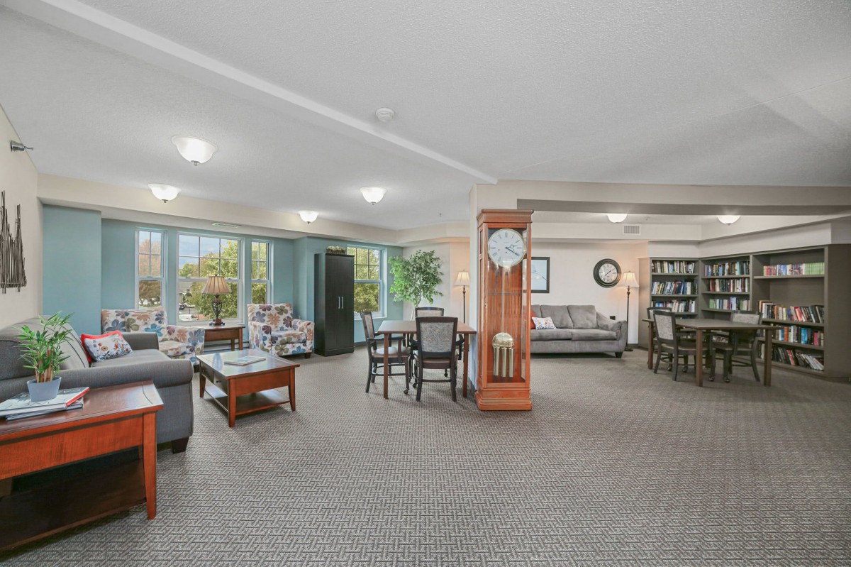 Spacious living area with comfortable seating, a dining table, and a bookshelf.
