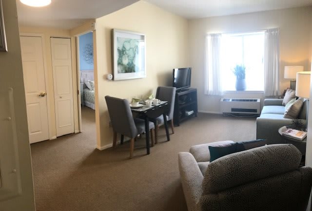 A cozy living room with a dining area, sofa, and television.