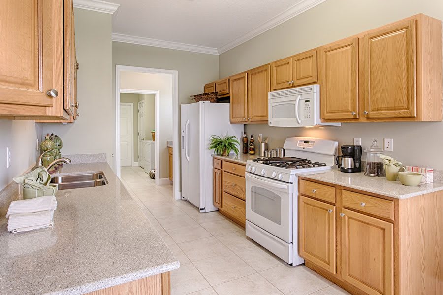 A modern kitchen with wooden cabinets and standard appliances.