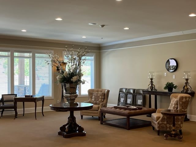 A well-decorated lobby area featuring elegant furniture and a floral centerpiece on a round table.