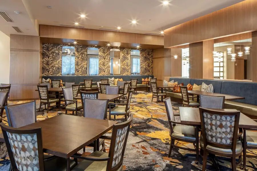 A spacious restaurant interior featuring multiple tables and chairs with elegant decor.