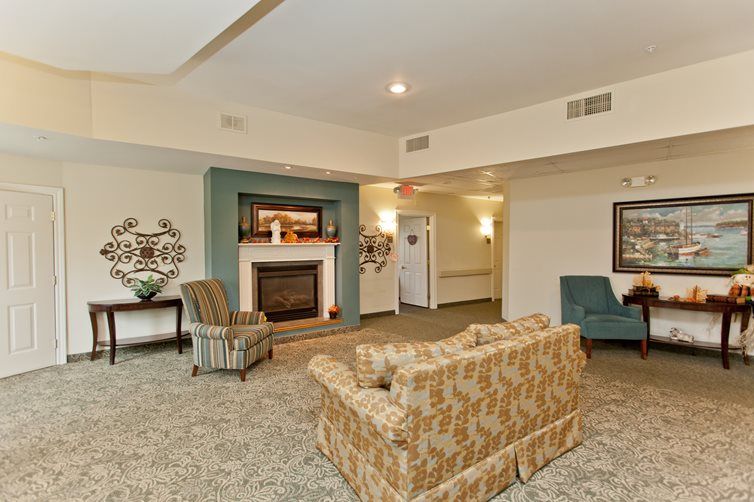 A cozy living room with a fireplace, featuring comfortable sofas and armchairs.