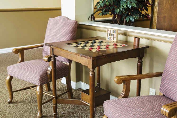 A cozy indoor setup with a chessboard and chairs, ready for a game.