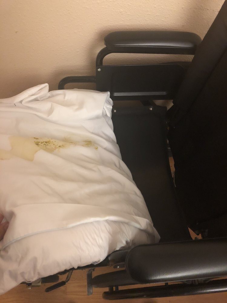 A hospital chair with stained linens.