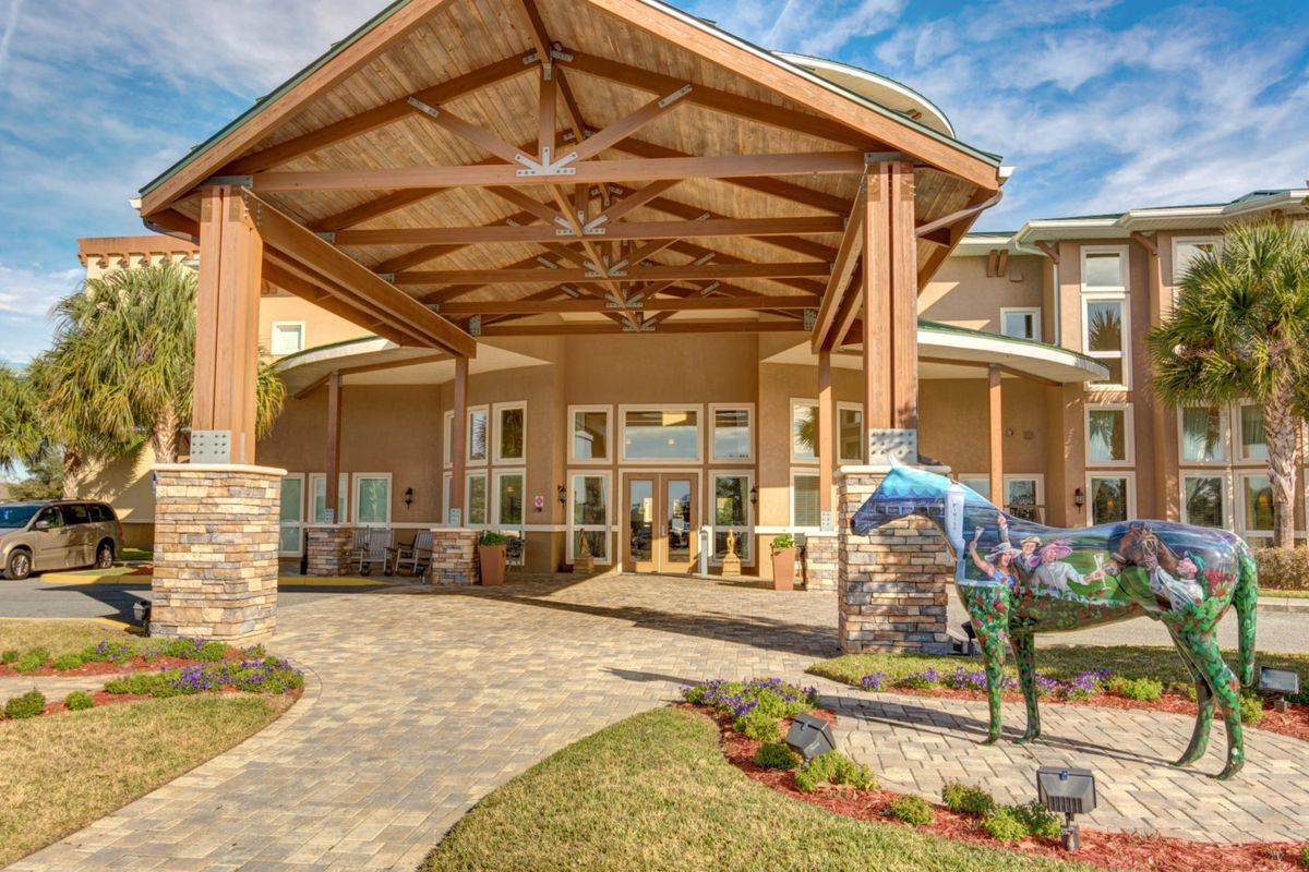 A welcoming building entrance with a covered walkway and landscaped surroundings.