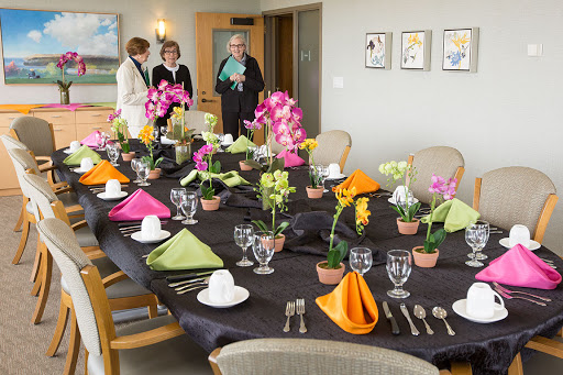 A beautifully arranged dining table with colorful flowers and elegant table settings, ready for a special event.