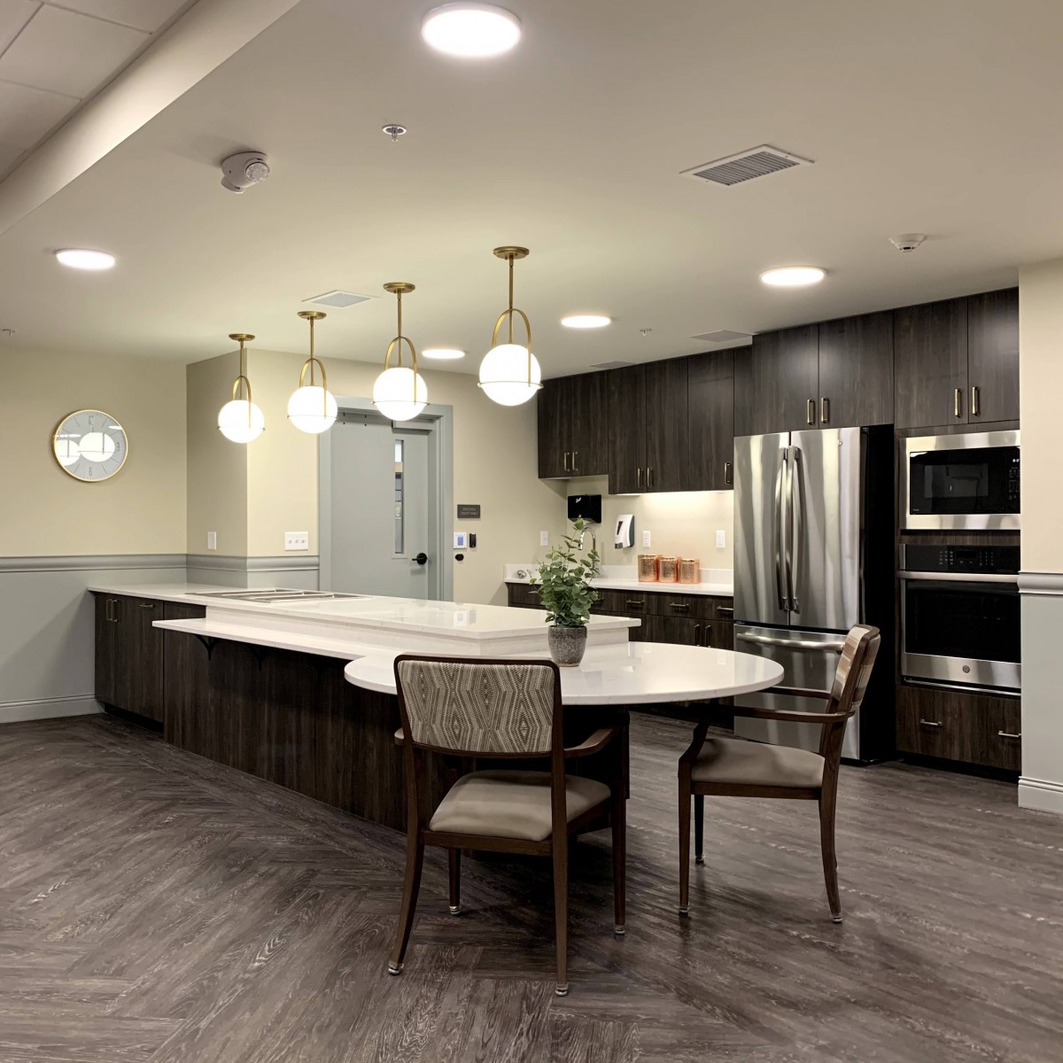 A modern kitchen with sleek design, featuring elegant lighting and stainless steel appliances.