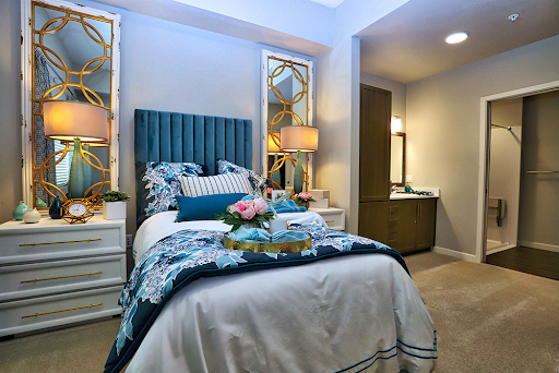 A stylish and modern bedroom featuring a blue headboard, cozy bedding, and elegant decor.