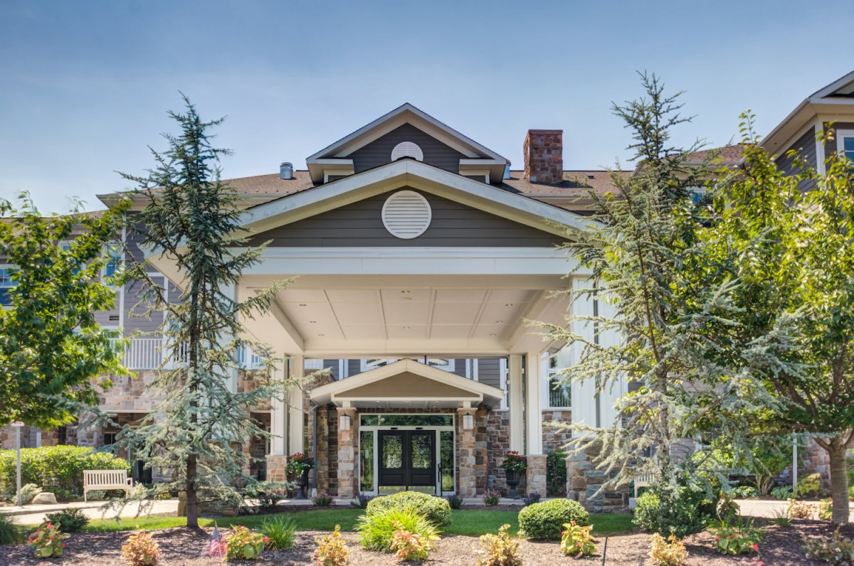 A grand entrance of a building surrounded by landscaping and trees.