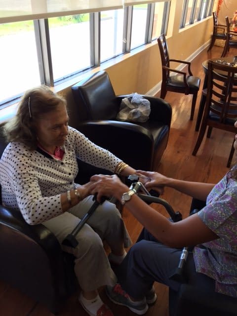 An elderly person receiving assistance in a comfortable indoor setting.