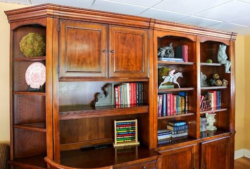 A beautifully crafted wooden bookshelf filled with an assortment of books and decorative pieces.