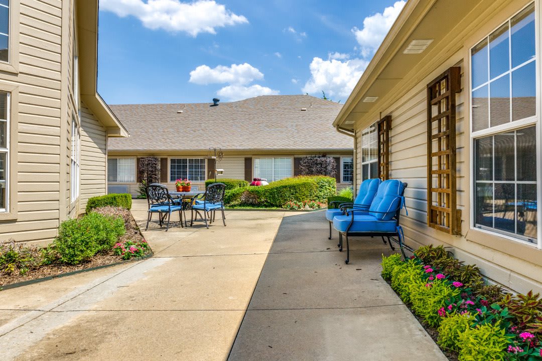 A sunny courtyard with patio furniture and well-maintained landscaping.