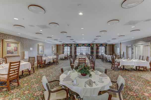 An elegant dining room with neatly arranged tables and chairs, featuring tasteful decor.