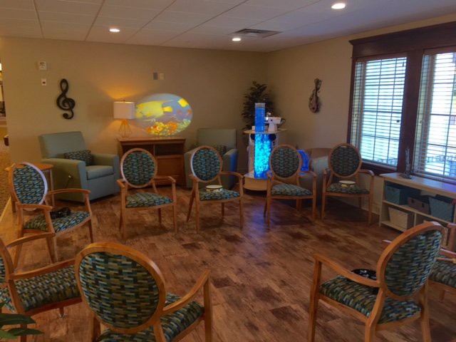 A cozy waiting room with chairs arranged in a circle, featuring warm lighting and decorative elements.