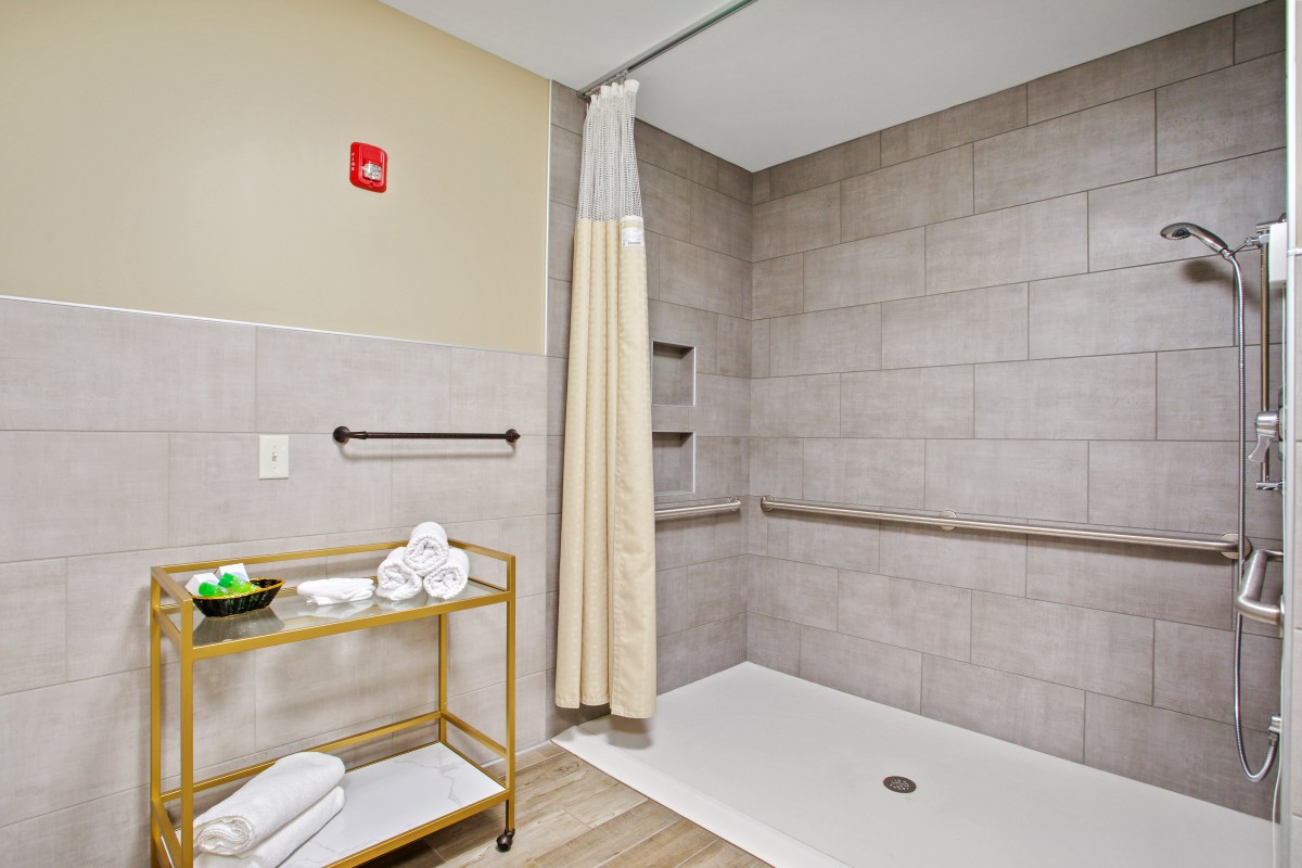Accessible bathroom with a spacious shower and safety features.