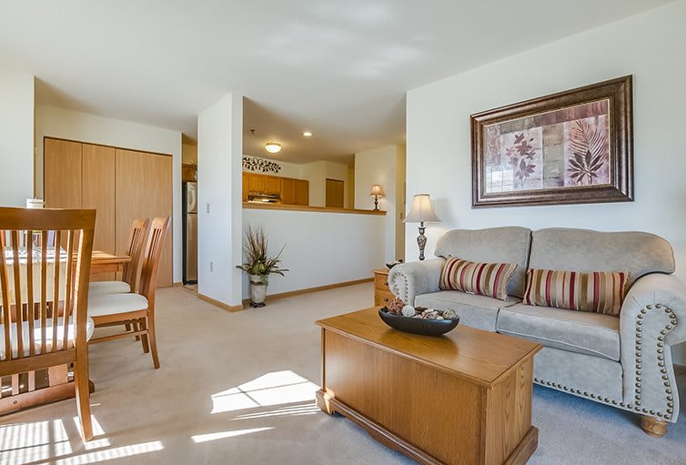 A cozy living room with a sofa and coffee table, adjacent to a kitchen and dining area.