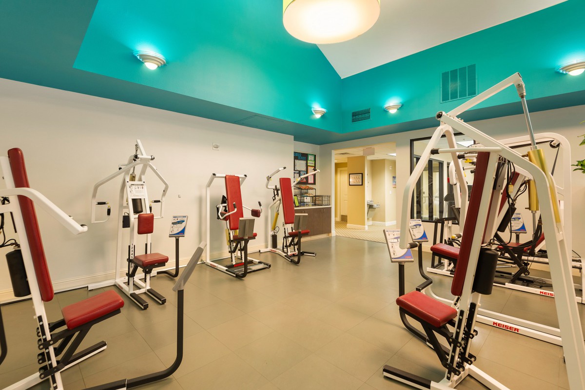 A modern gym equipped with various exercise machines in a spacious interior.