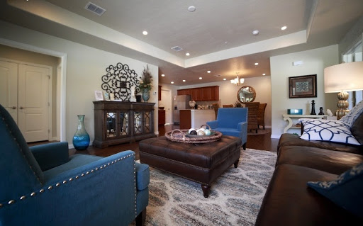 A stylish living room featuring blue accent chairs, a central coffee table, and elegant decor.