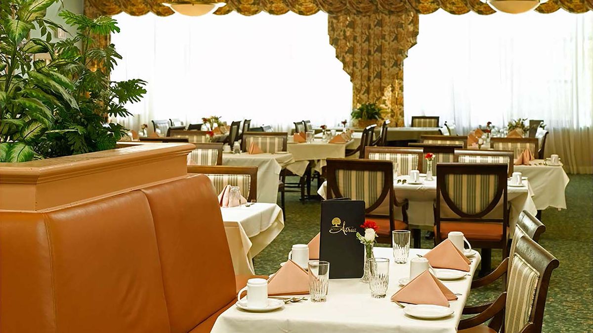 An elegant restaurant interior with neatly arranged tables and chairs, ready for guests.