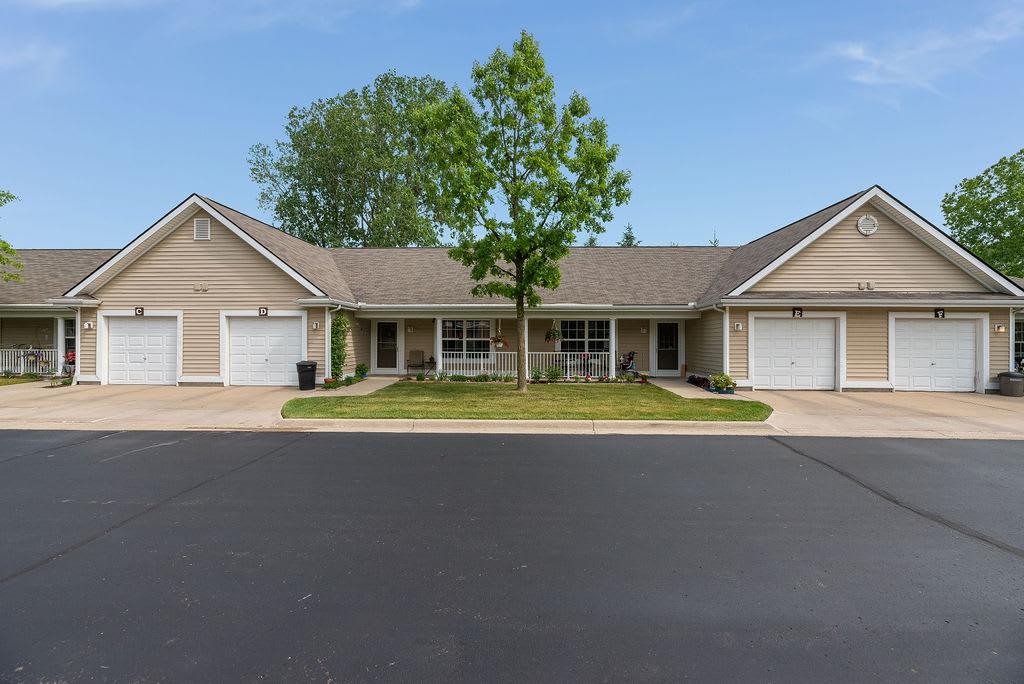 A suburban duplex with well-maintained lawns and a central tree.