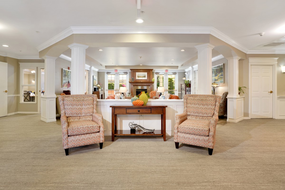 A cozy living room with two upholstered chairs and a central wooden table adorned with decorative items.
