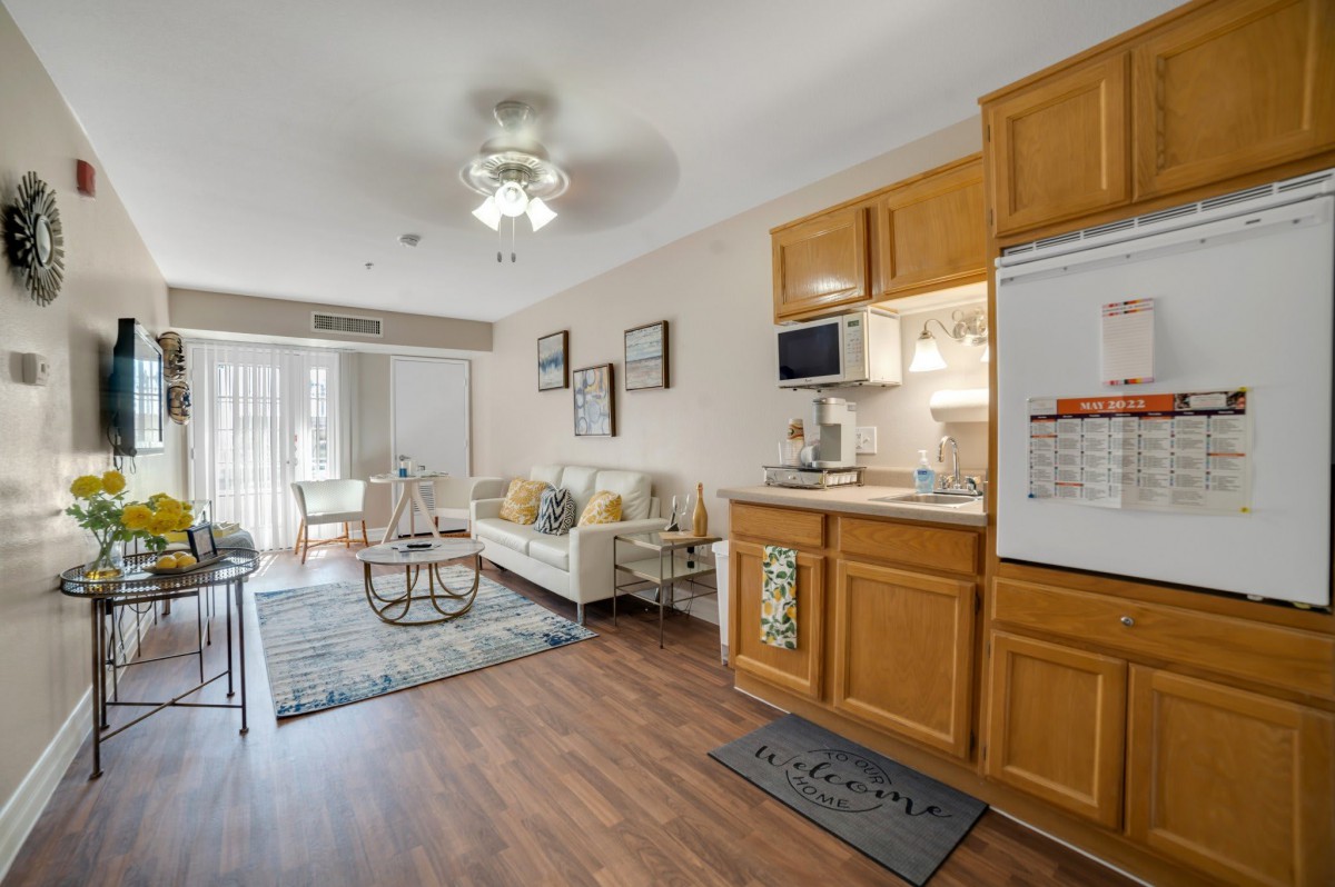 A cozy apartment with an open-plan living area and kitchen, featuring wooden cabinetry and modern furnishings.