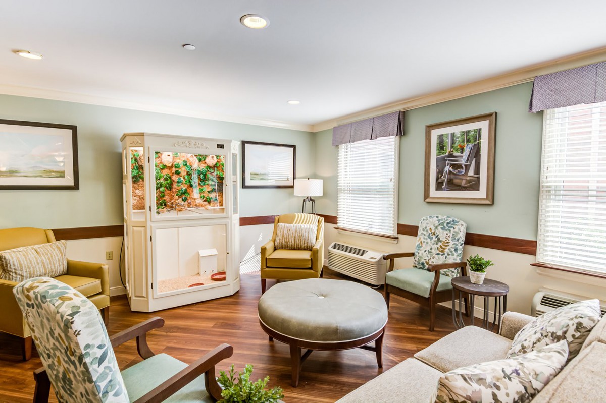 A cozy living room with comfortable seating and a large aquarium.