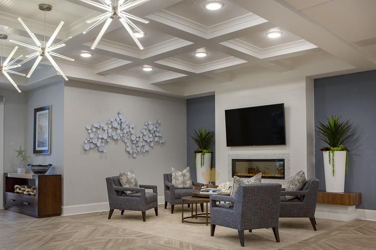 A modern living room featuring comfortable seating, wall art, and a large television.