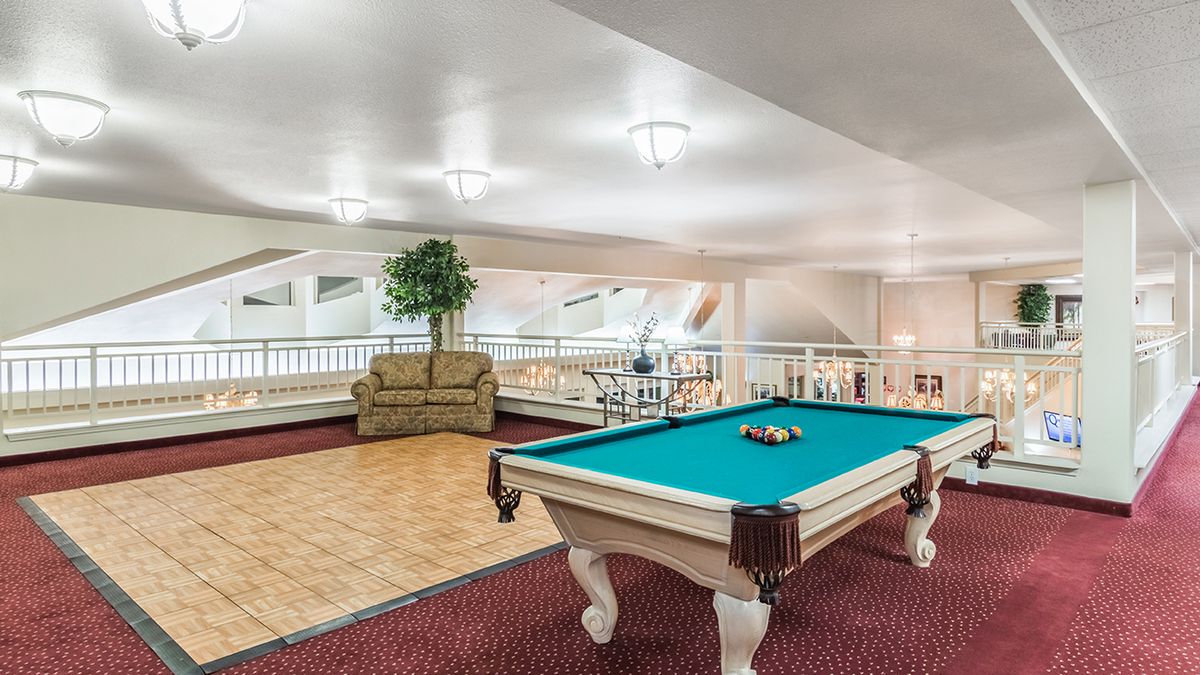 A billiard room featuring a pool table and seating area.