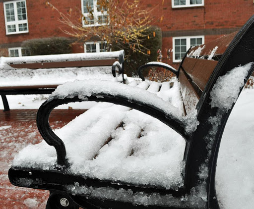 A snowy bench adorned with a fresh layer of snow, capturing the essence of winter.