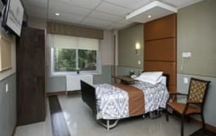 A clean and well-organized hospital room featuring a single bed.